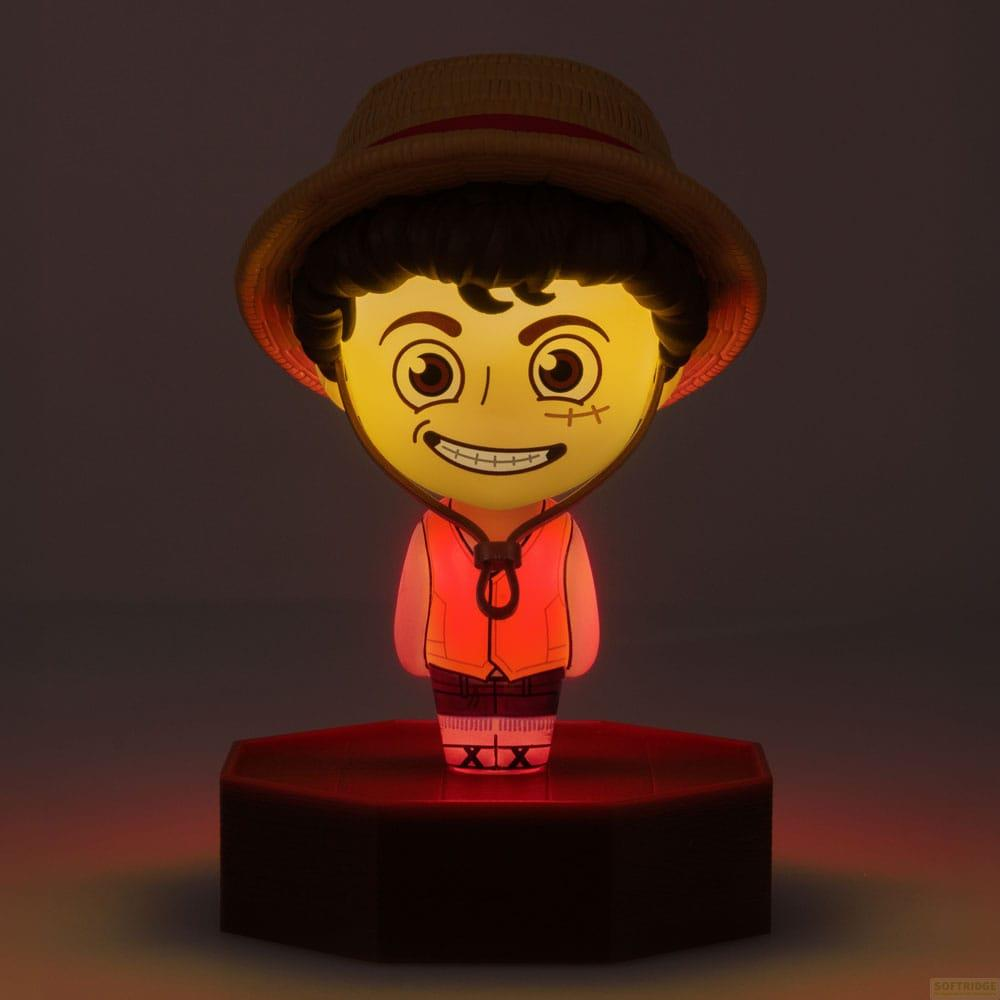 Podświetlana figurka w stylu anime z kapeluszem słomkowym i pomarańczową kamizelką na ciemnej podstawie.