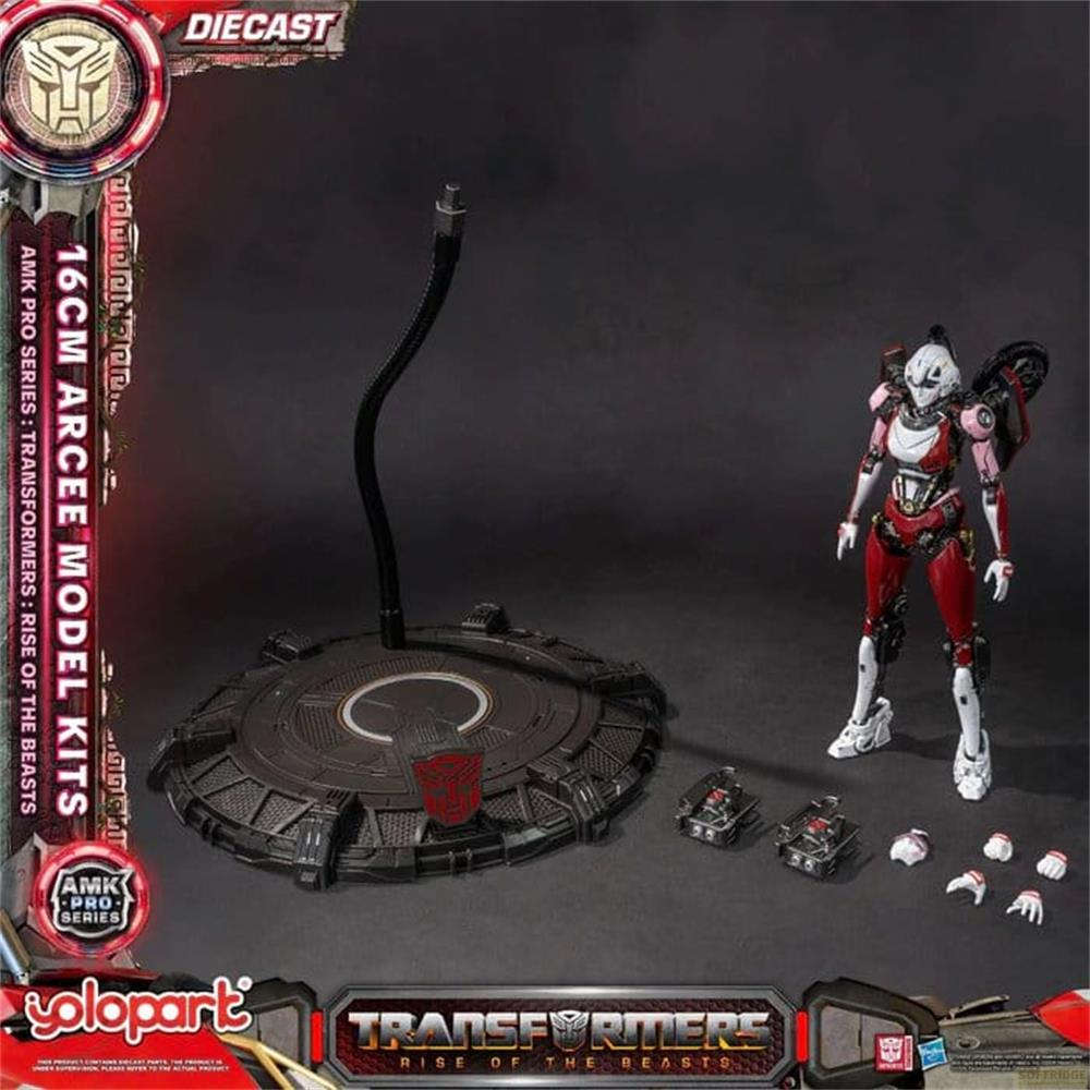 Eine Arcee-Figur in Rot und Weiß steht neben einem Display-Ständer und kleinen Fahrzeugen.