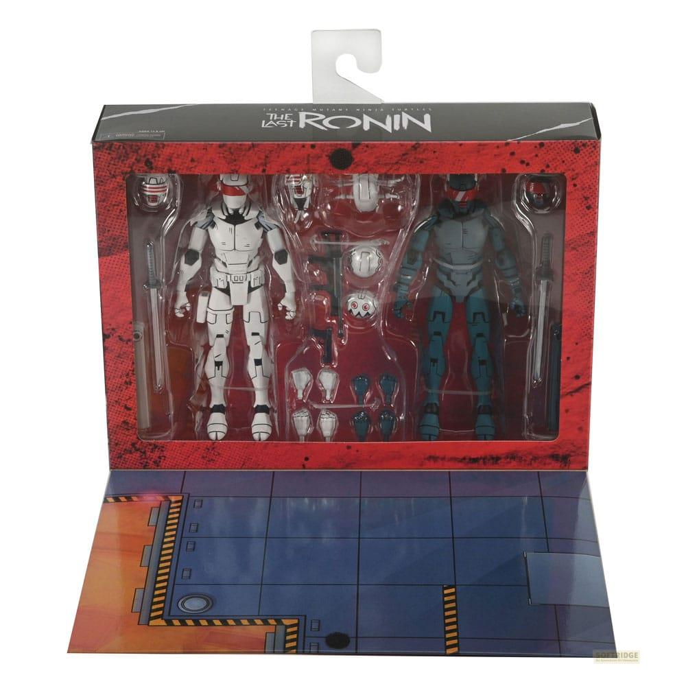 Caja con dos figuras de acción: una blanca, una gris-azul, con armas.