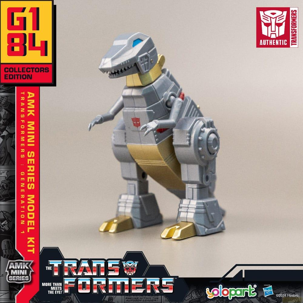 Ein graues und goldenes Transformers-Dinosaurier-Spielzeug steht auf einem grauen Hintergrund.