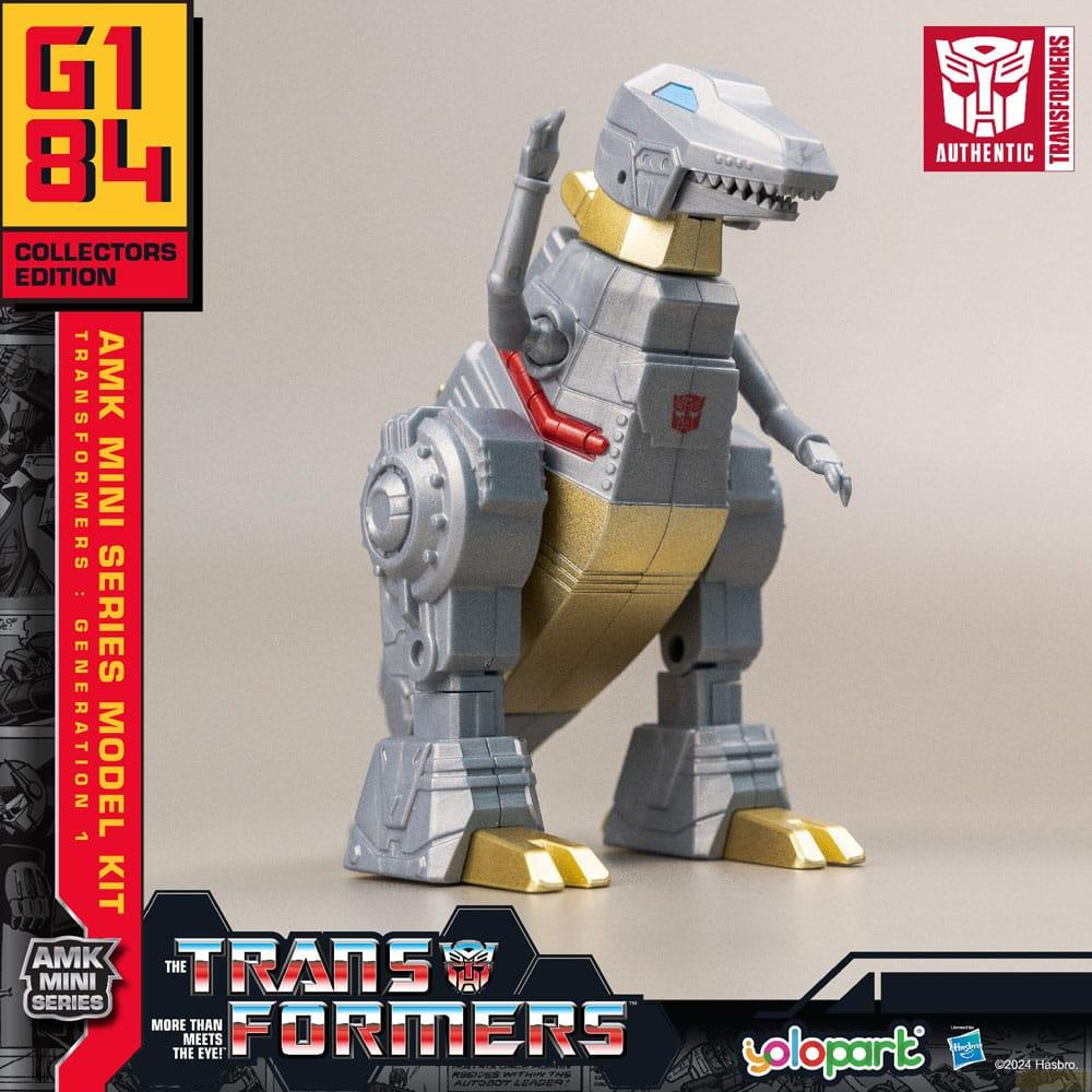 Ein silberner Roboter in Dinosaurierform mit goldenen Akzenten steht auf einem grauen Hintergrund.