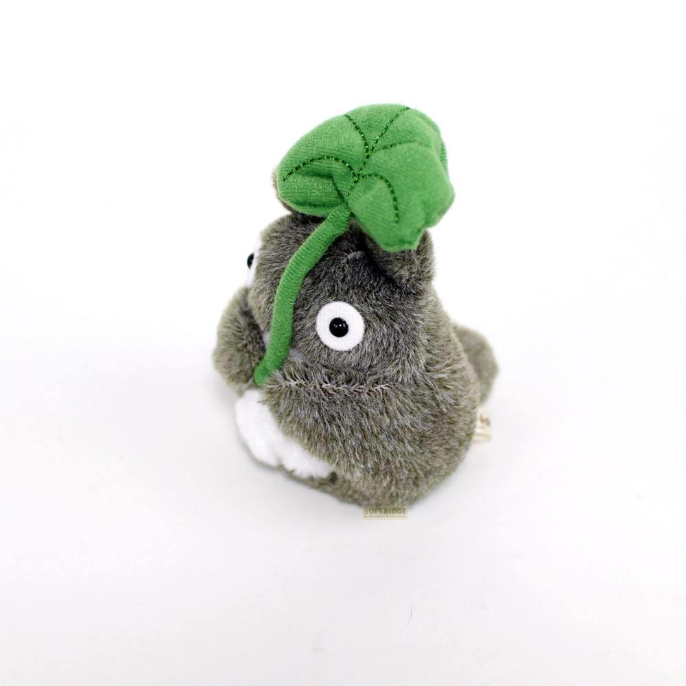 Totoro en peluche grise avec une feuille verte sur la tête sur fond blanc.