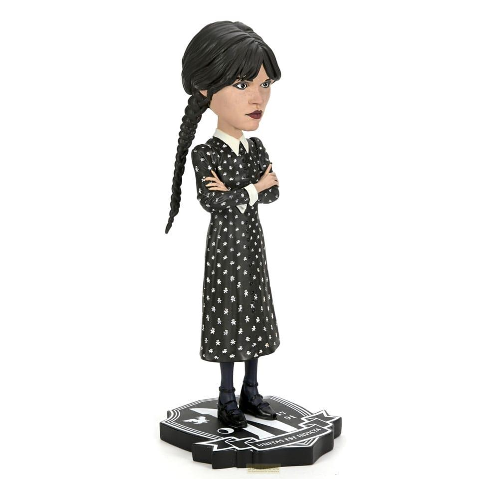 Figura de Wednesday Addams con vestido negro de puntos blancos y trenzas sobre base.