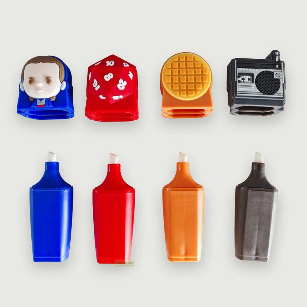 Acht Schreibwarenartikel: ein blauer Kopf, ein roter Würfel, ein gelber Waffelhalter, ein Radio, vier Marker.