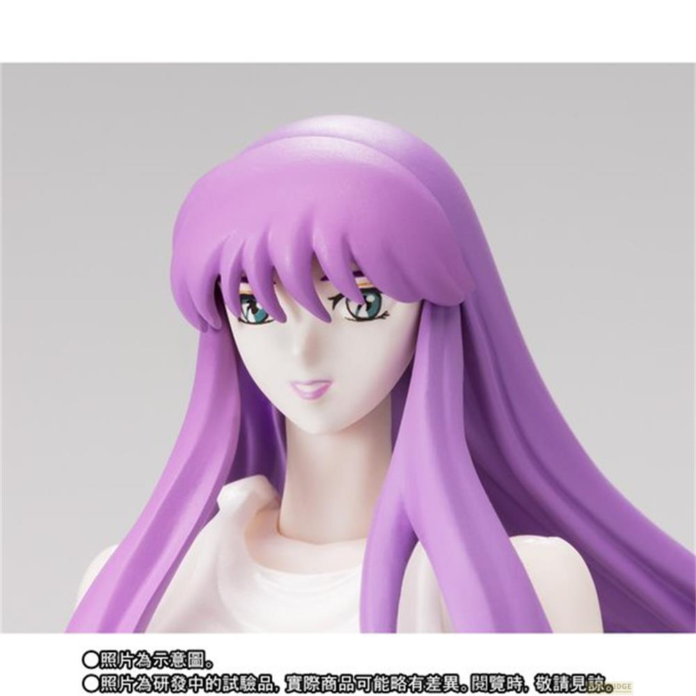 Una figura con capelli viola, occhi blu, pelle bianca e un vestito bianco.