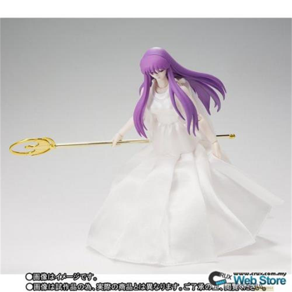 Una figura in abito bianco con capelli viola tiene un bastone dorato.
