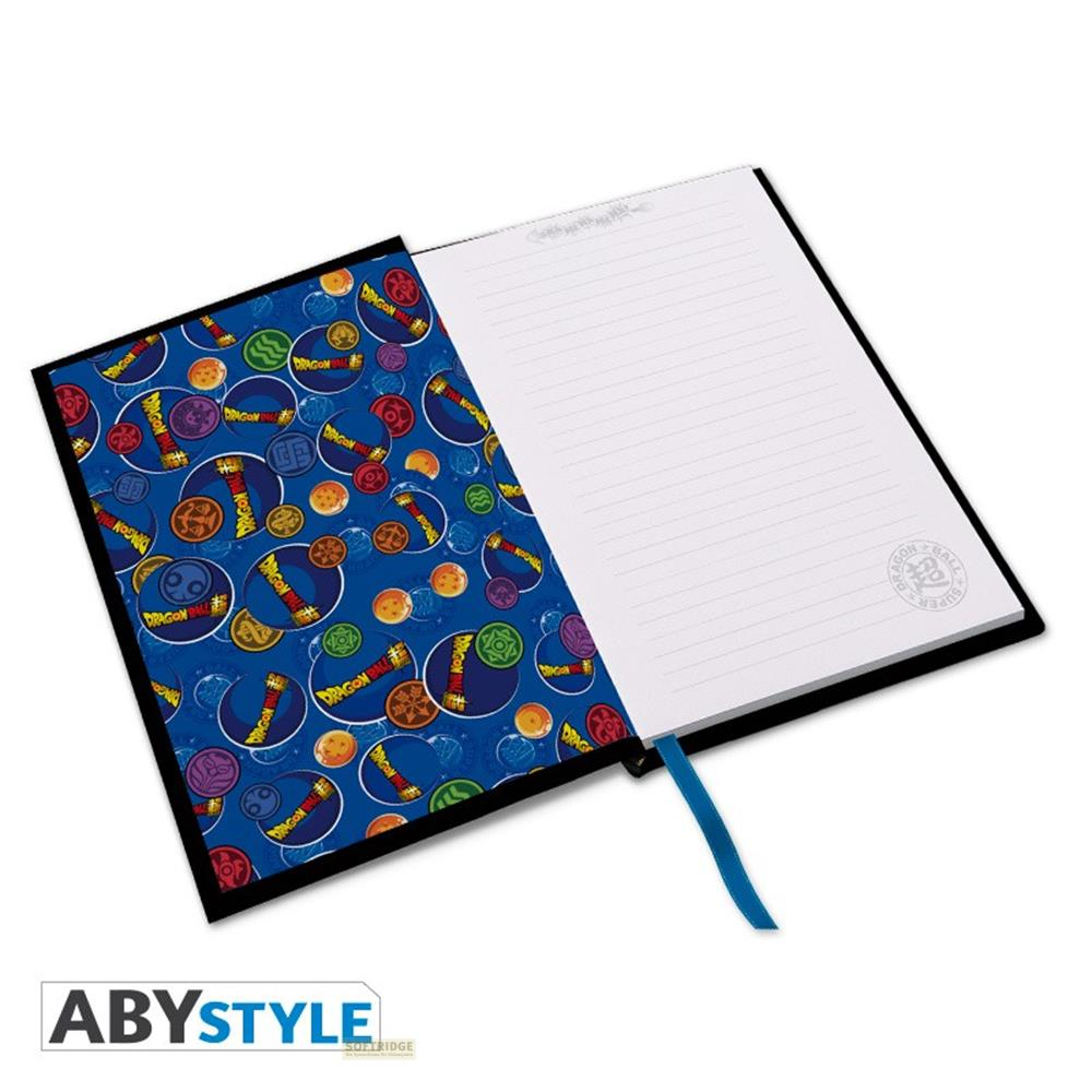 Un carnet ouvert avec un motif Dragon Ball sur la couverture gauche et des pages vierges.