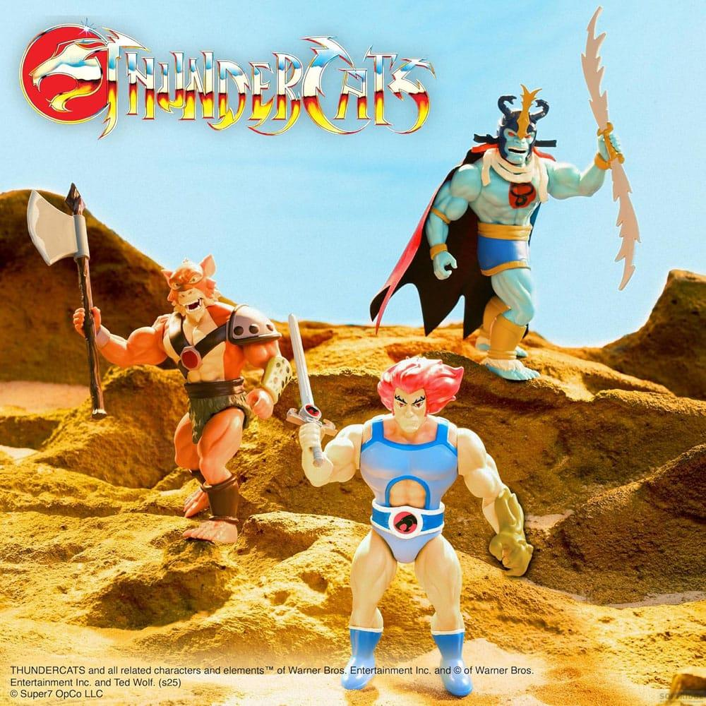 Tre action figure dei ThunderCats su un paesaggio sabbioso con cielo blu.
