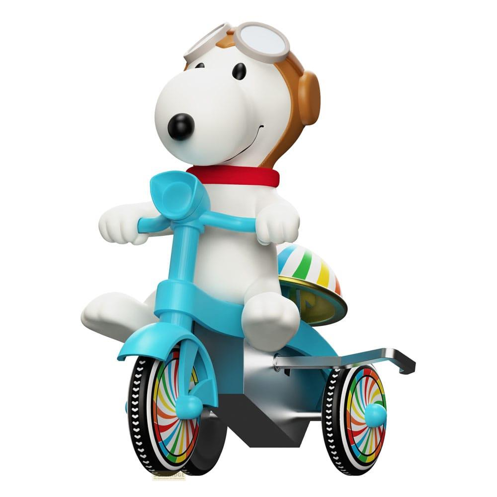 Snoopy in tenuta da pilota guida un triciclo con ruote colorate.