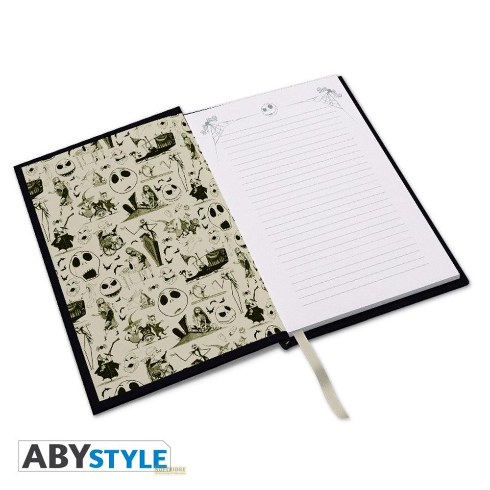 Un carnet ouvert avec un motif "L'Étrange Noël de Monsieur Jack" sur la page de gauche.