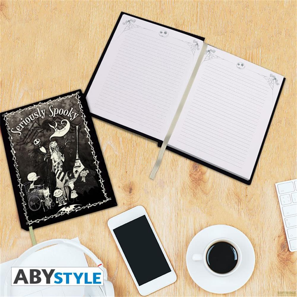 Un carnet effrayant, smartphone, écouteurs et tasse de café sur un bureau.