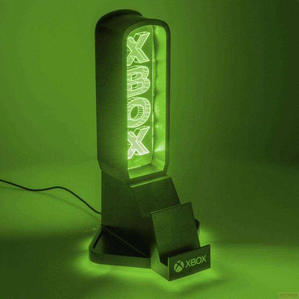 Zielony stojak Xbox z podświetlanym logo świeci na zielonym tle.