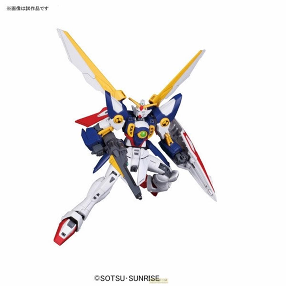 Un robot blanc, bleu et jaune avec des ailes tenant une arme.