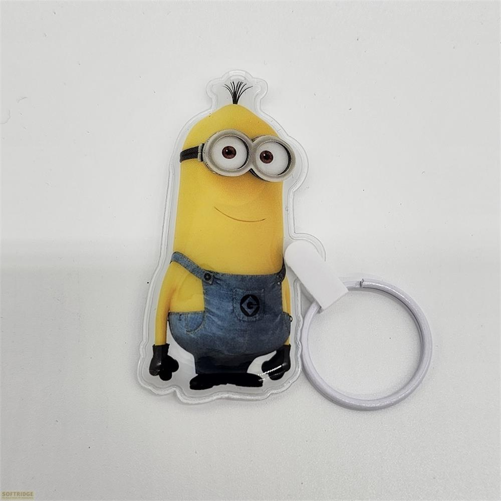 Ein gelber Minion-Schlüsselanhänger mit blauer Latzhose und Brille auf weißem Hintergrund.