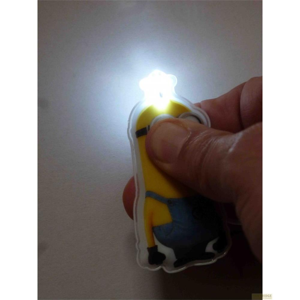Ein Minion-Schlüsselanhänger mit leuchtender Lampe wird von einer Hand gehalten.