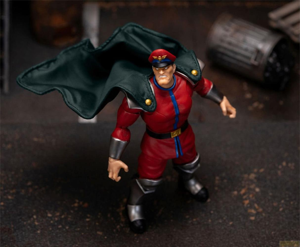 Eine Actionfigur mit rotem Anzug, schwarzem Cape und roter Mütze steht.