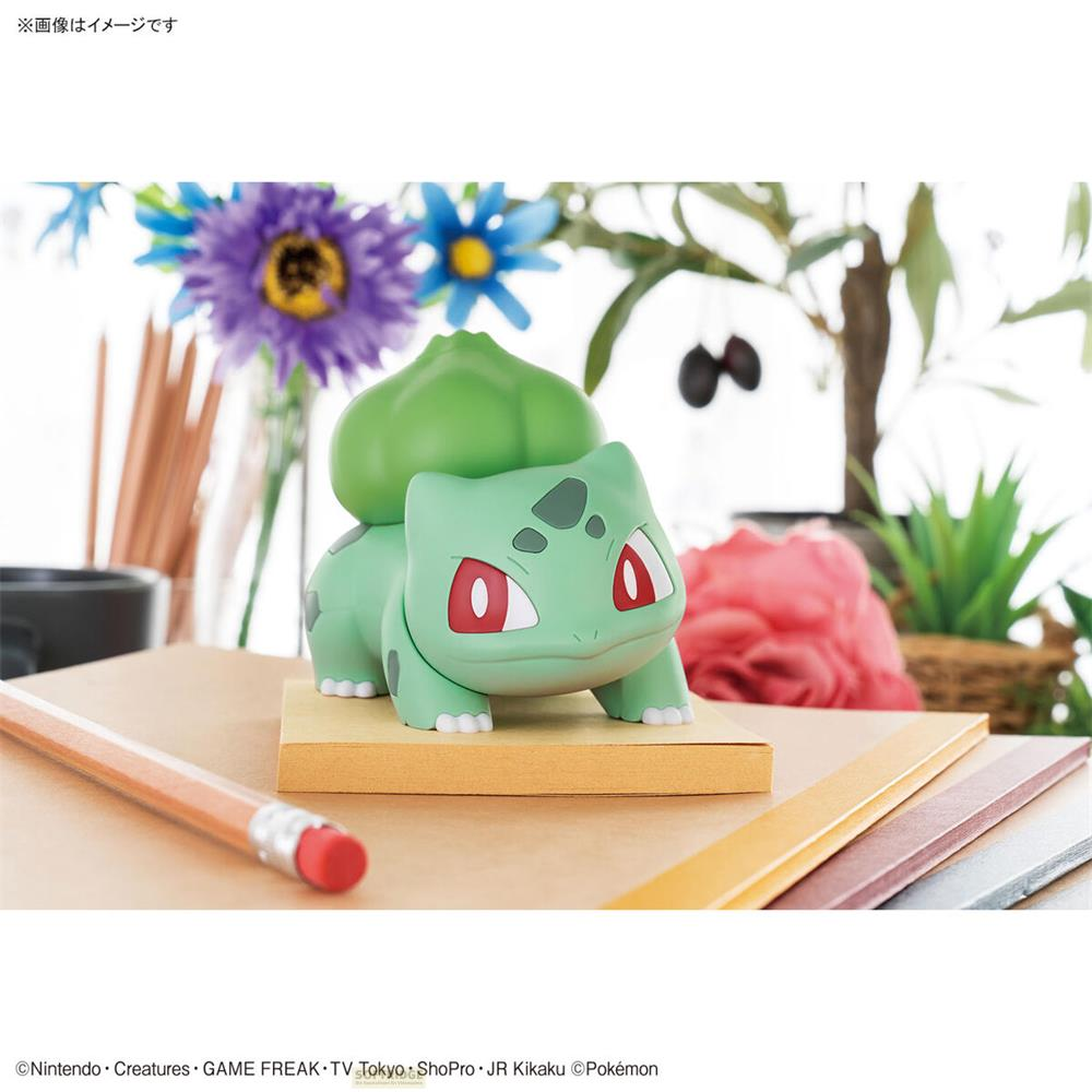 Une figurine verte de Bulbizarre se tient sur un socle avec des crayons et des livres.
