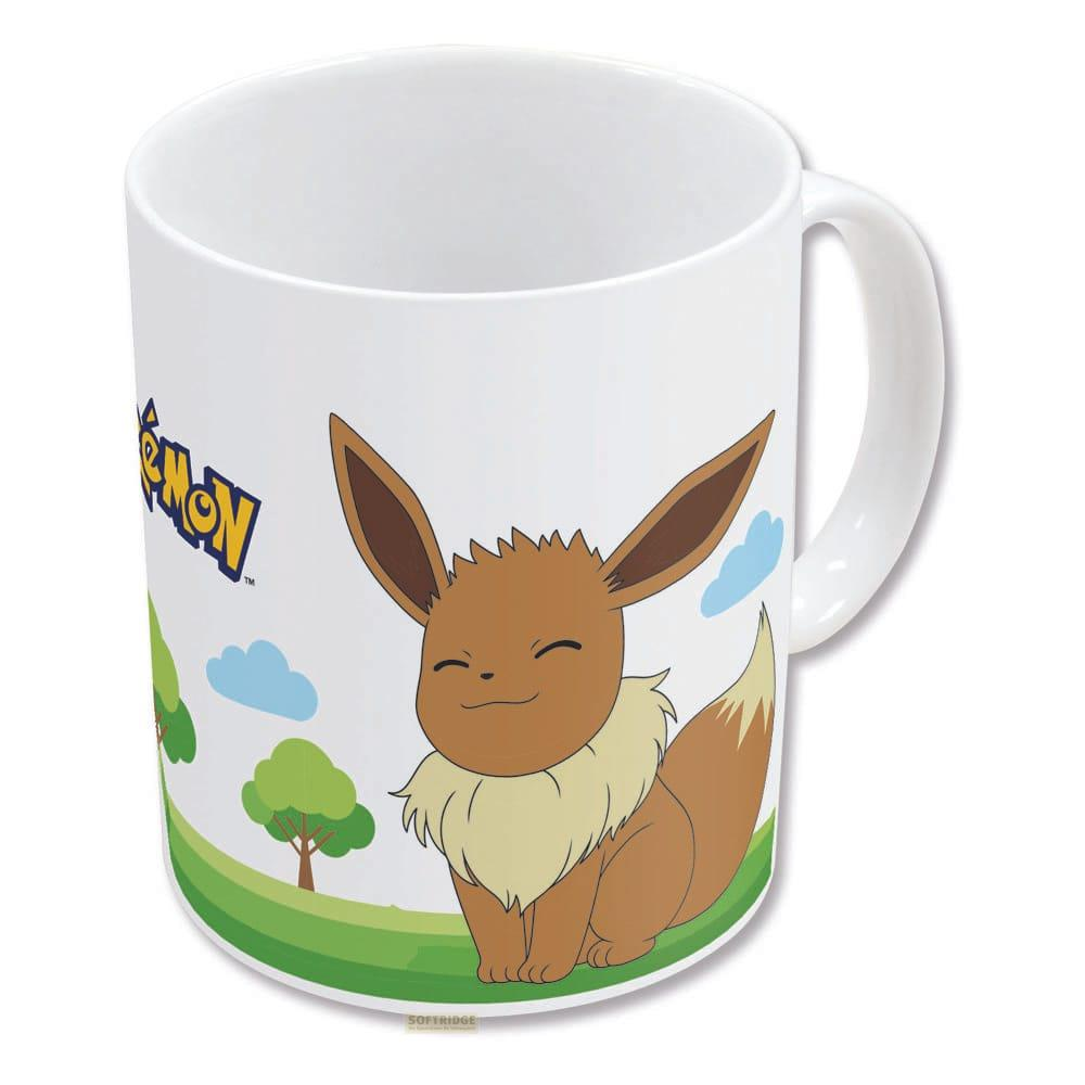 Une tasse avec Evoli et le logo Pokémon sur un paysage verdoyant.