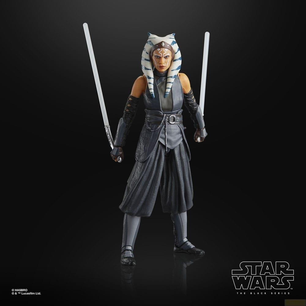Una figura de acción de Ahsoka Tano con dos sables de luz se alza sobre fondo negro.