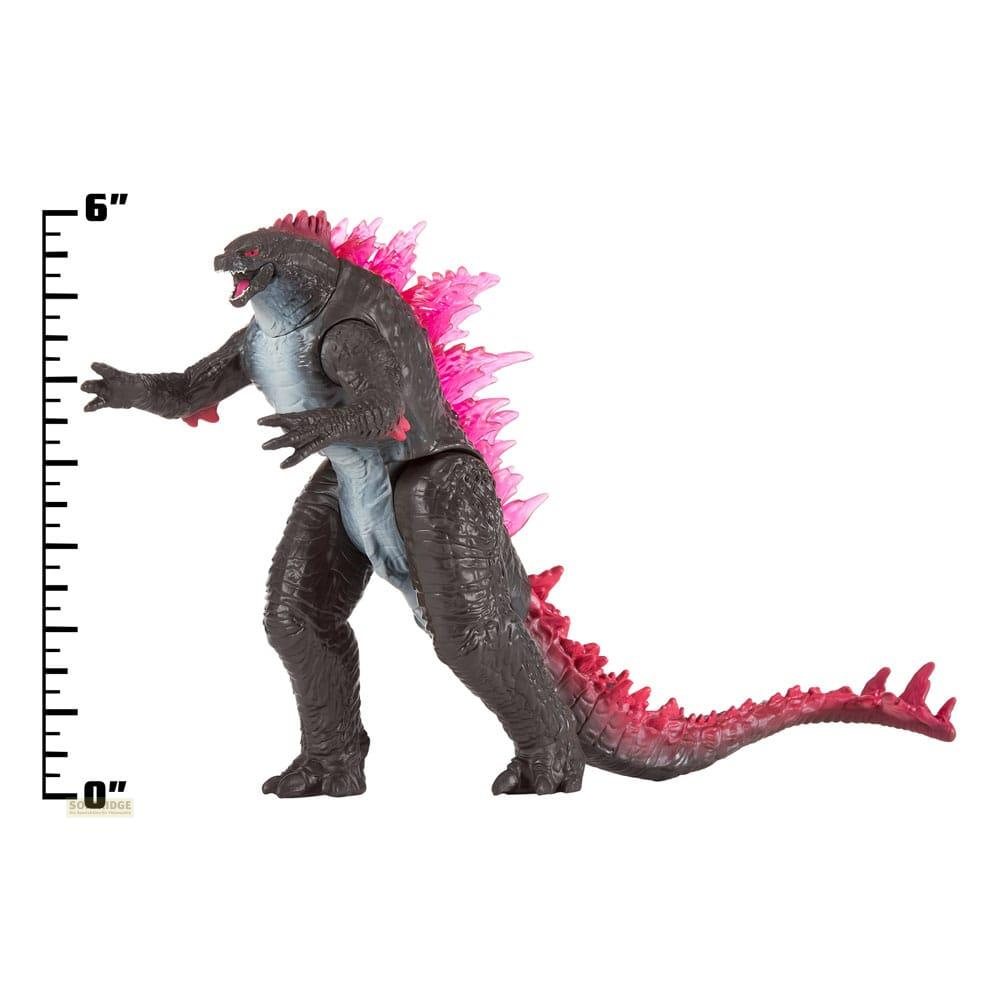 Figura scura di Godzilla con pinne dorsali rosa e una scala graduata.