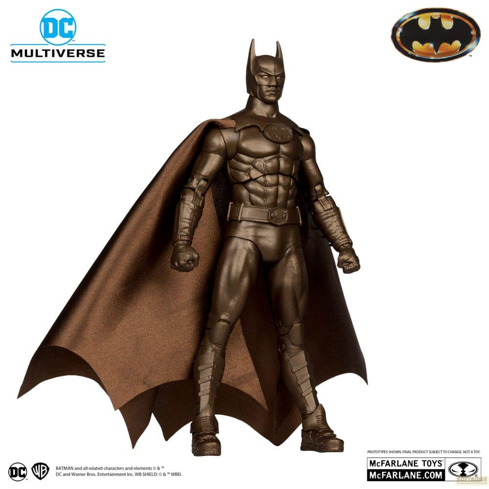 Une figurine de Batman en bronze avec cape se tient sur fond blanc.