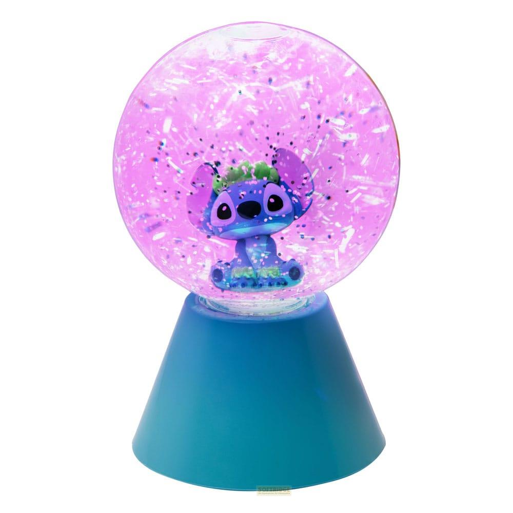 Niebieski Stitch siedzi w różowej kuli z brokatem na niebieskiej podstawie.