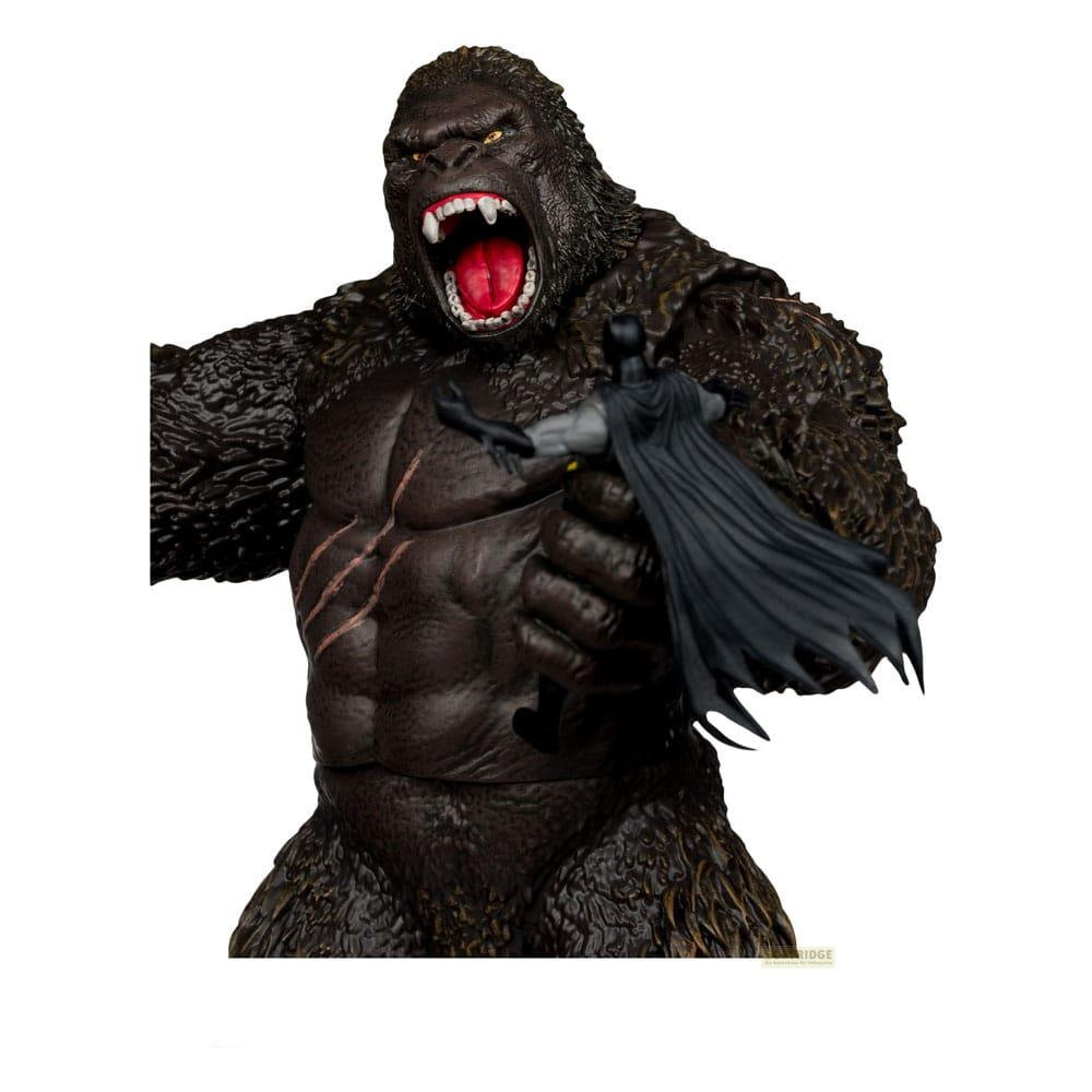 Un gorila gigante, marrón oscuro, con la boca abierta, sostiene una figura de Batman.