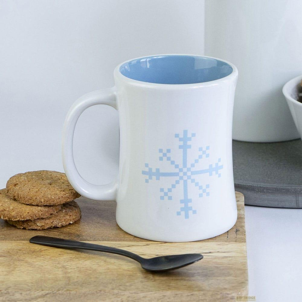 Una taza blanca con diseño de copo de nieve y interior azul.