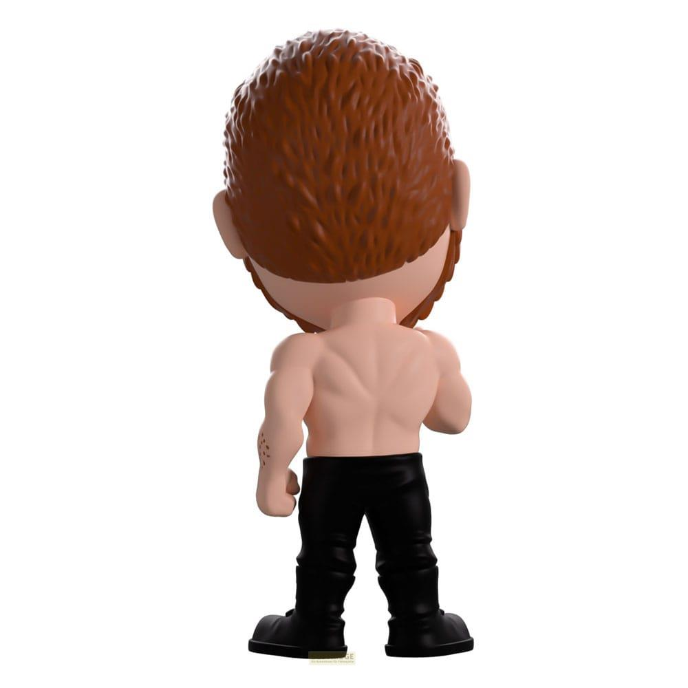 Rückansicht einer Actionfigur mit braunem Haar, nacktem Oberkörper und schwarzen Hosen.