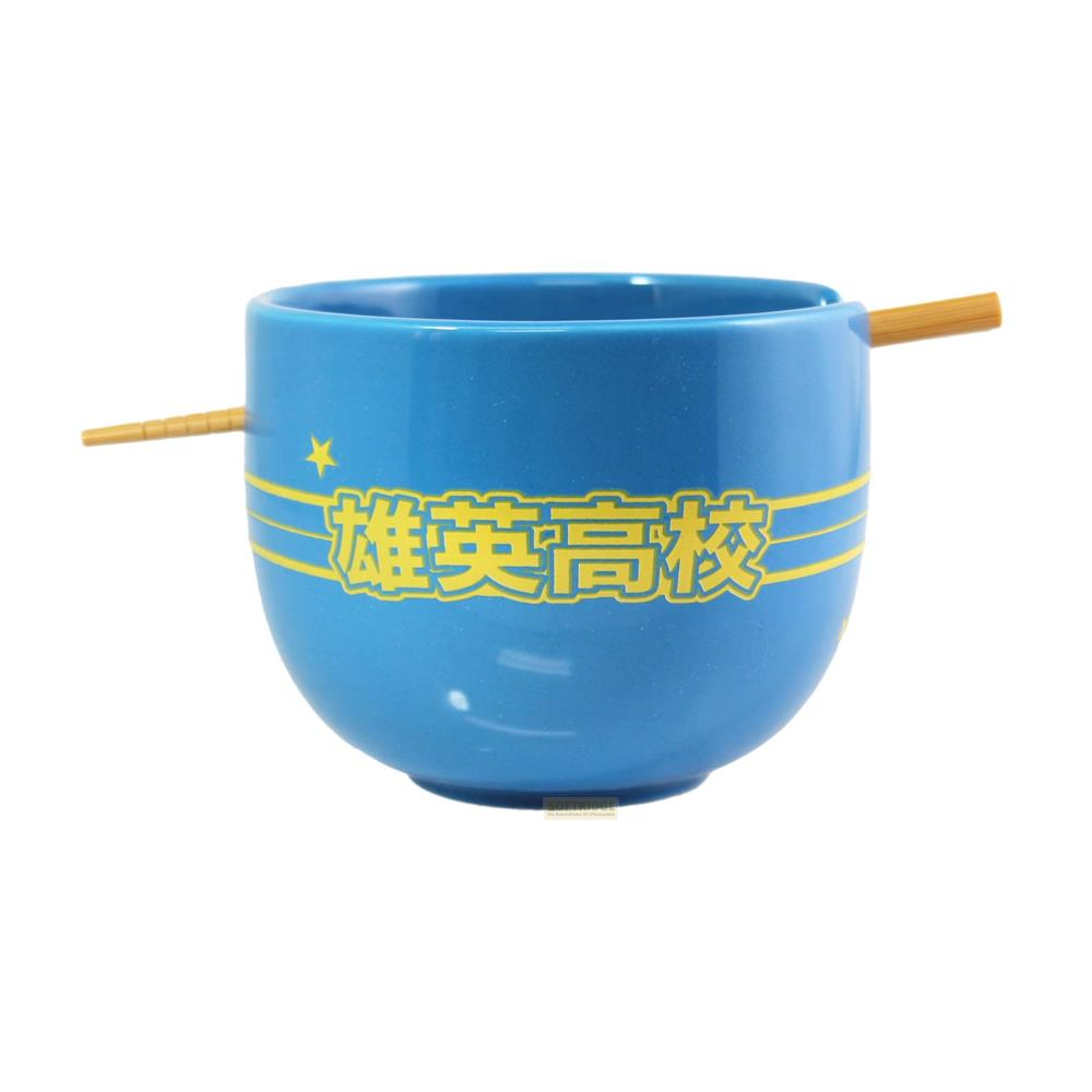 Eine blaue Schüssel mit japanischen Schriftzeichen und gelben Streifen, daneben Stäbchen.