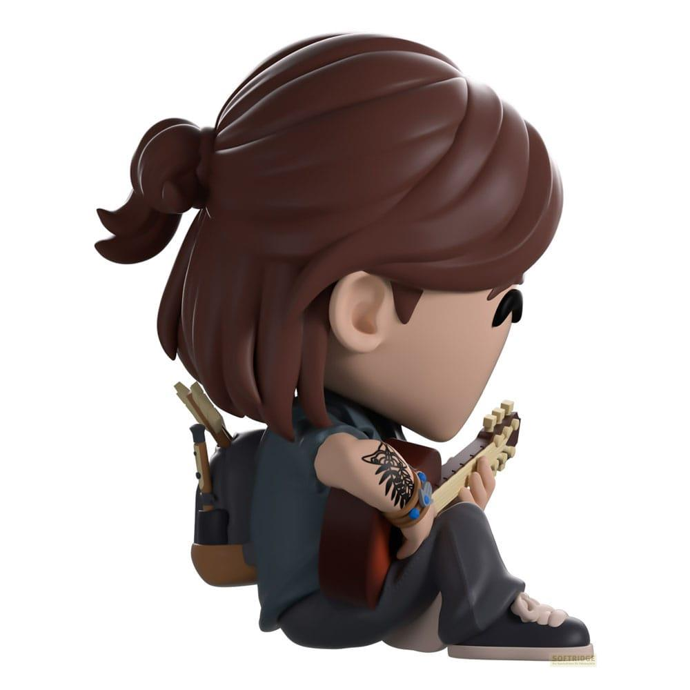 Una figura de pelo castaño toca la guitarra, con mochila y tatuaje en el brazo.