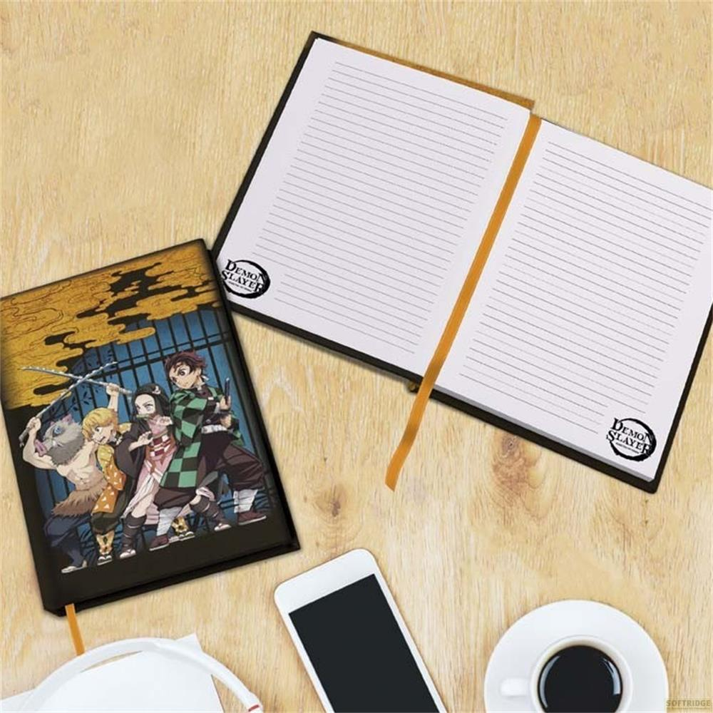 Un carnet Demon Slayer, un smartphone et une tasse de café sur fond de bois.