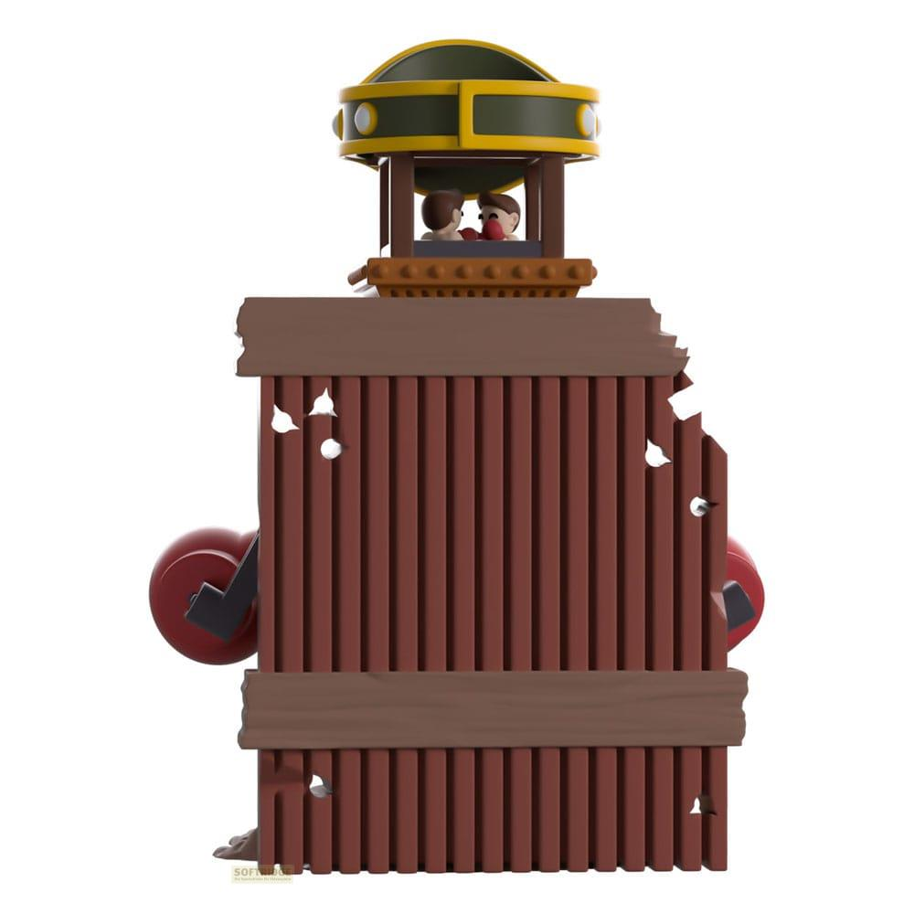 Eine hölzerne Struktur mit zwei Figuren in einem oberen Turm, rote Räder an den Seiten.