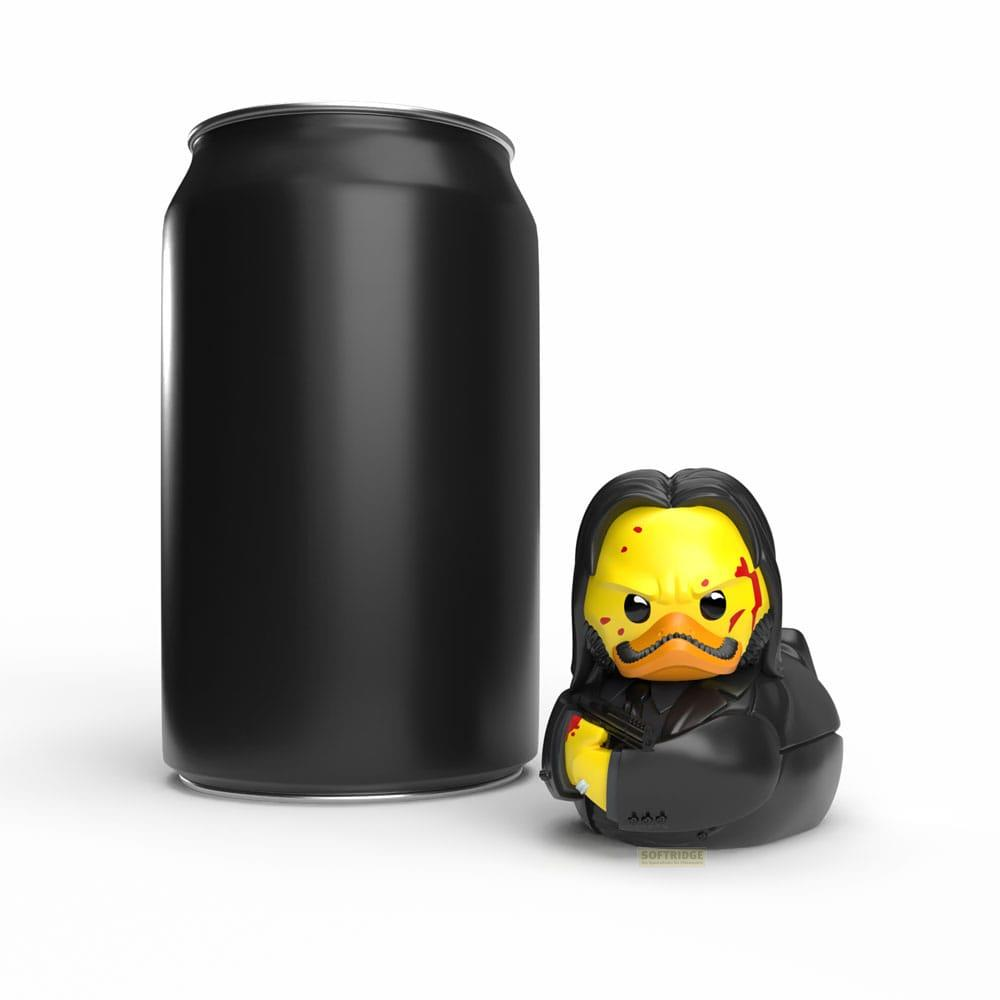 Lata negra junto a un pato de goma amarillo con traje negro y bigote.