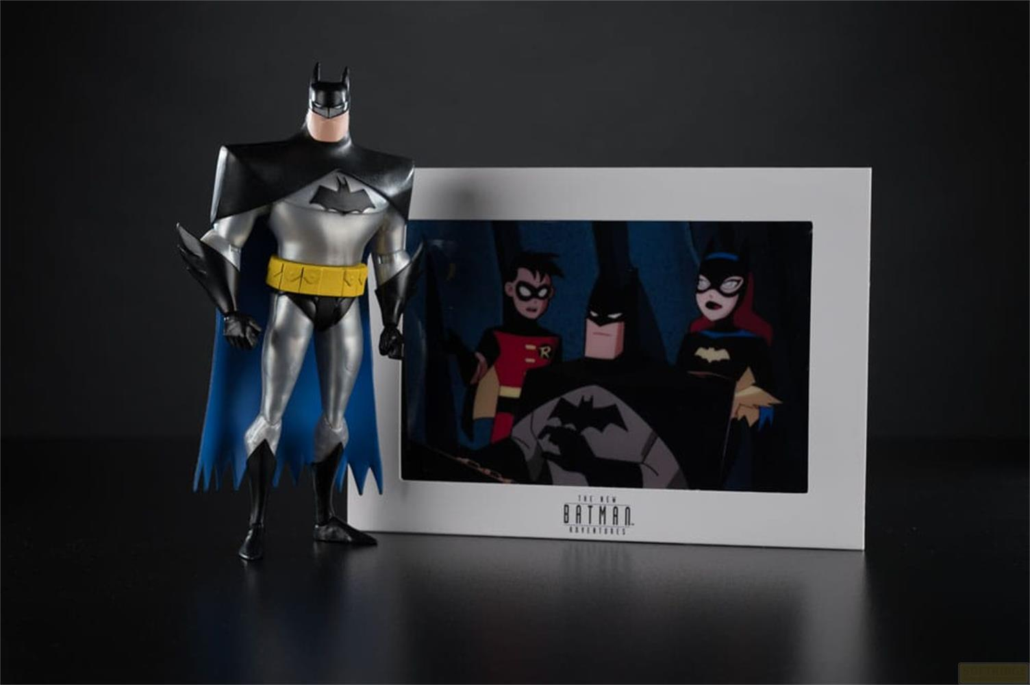 Una figura di Batman accanto a un'immagine di Batman, Robin e Batgirl.