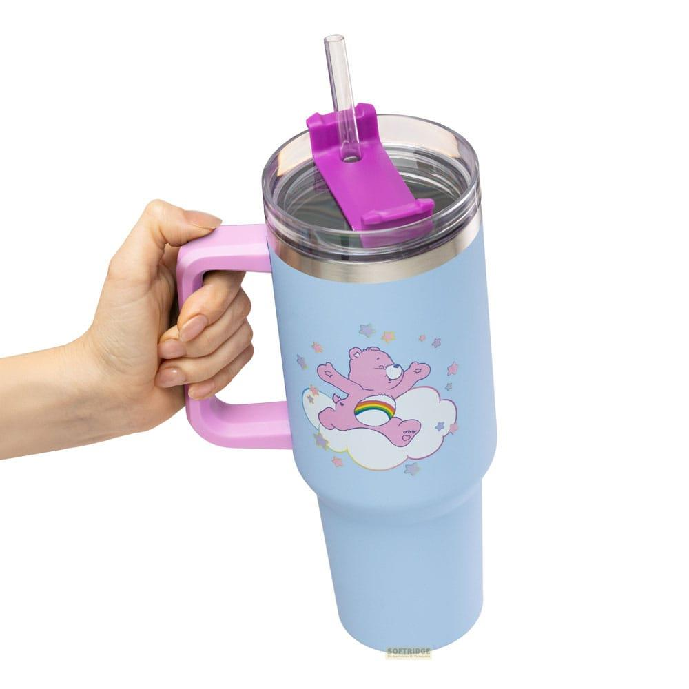 Eine Hand hält eine hellblaue Tasse mit einem rosa Bären auf einer Wolke.