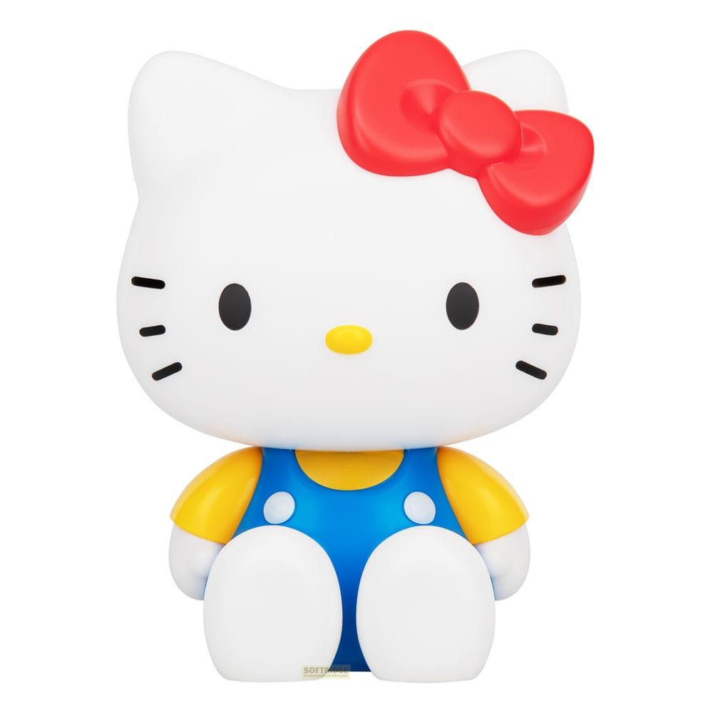 Biała figurka Hello Kitty z czerwoną kokardką, żółtą koszulką i niebieskimi ogrodniczkami.