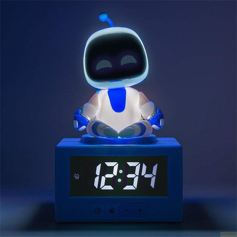Niebieski cyfrowy budzik z siedzącym robotem jako lampką nocną.