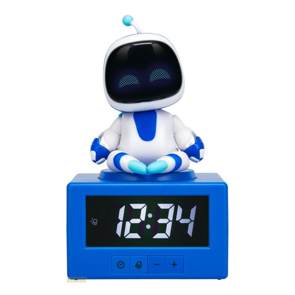 Mały biało-niebieski robot siedzi na niebieskim cyfrowym budziku.