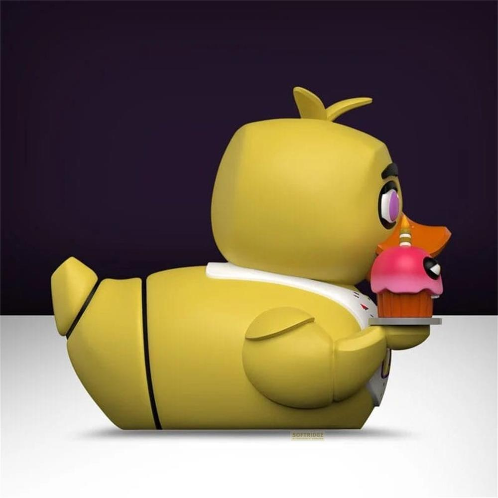 Gelbe Entenfigur mit Cupcake auf einem Tablett, dunkler Hintergrund.