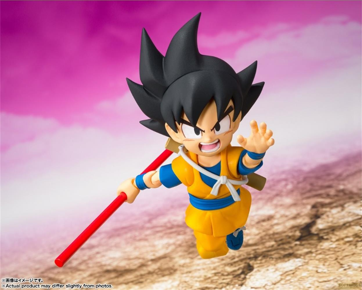 Una figura de acción de Goku sostiene un bastón rojo. Viste un gi naranja.