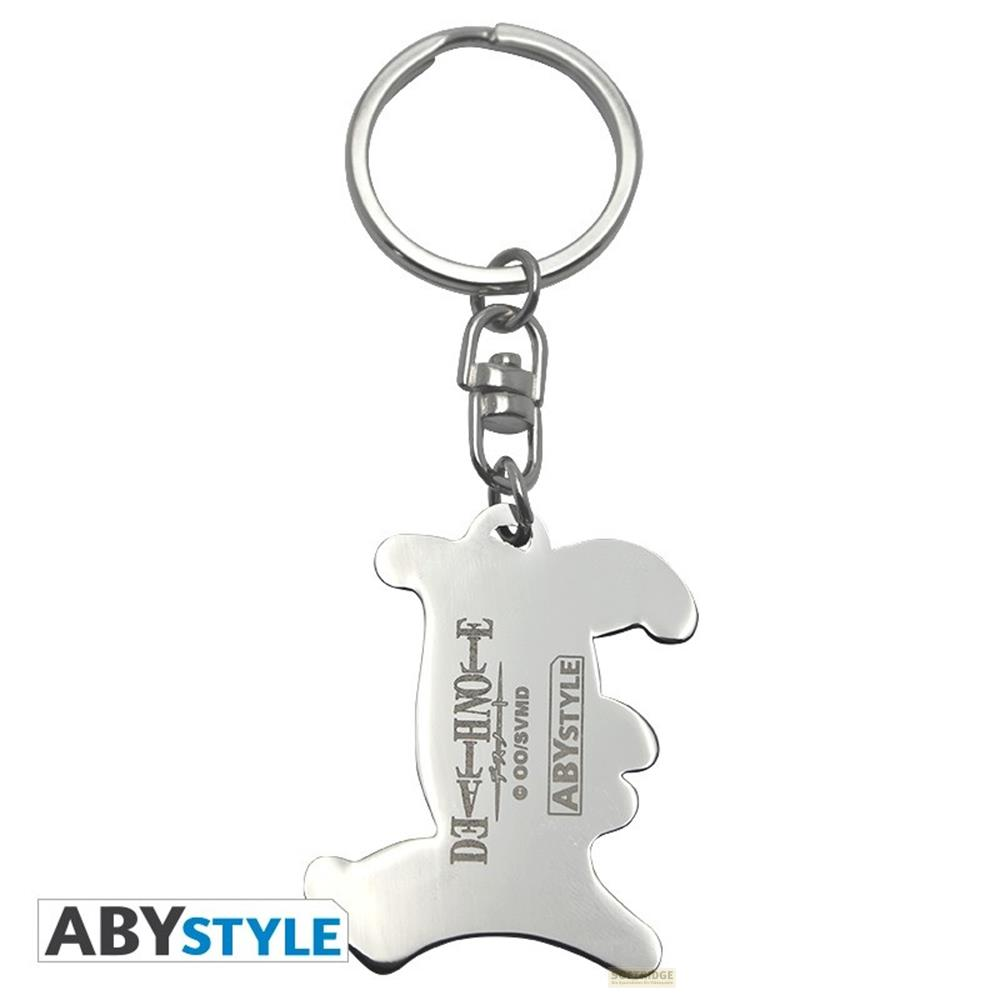 Un llavero plateado con forma de personaje, con logo "DEATH NOTE" y texto ABYSTYLE.