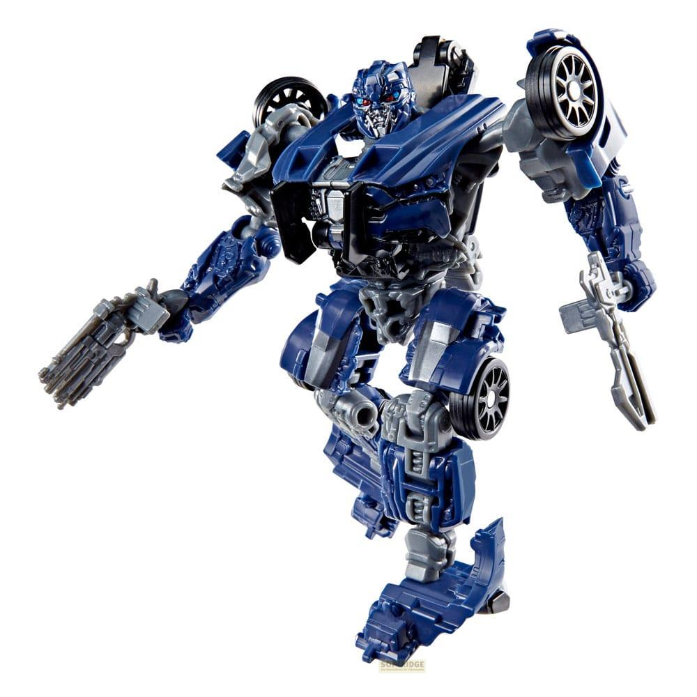 Un transformer blu e grigio con armi sta con le braccia tese.