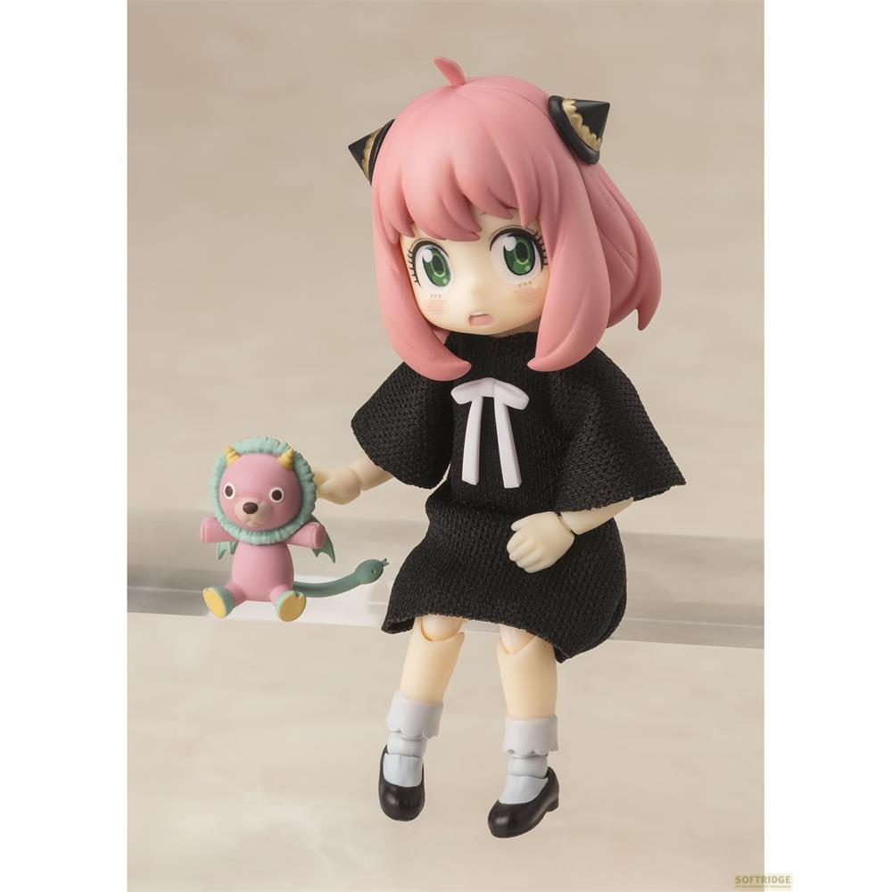 Una figura con capelli rosa e vestito nero tiene un piccolo peluche rosa.