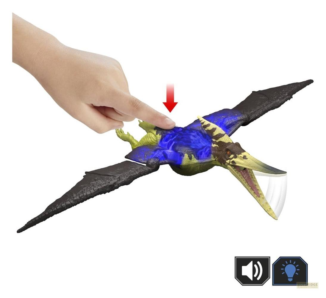 Un dedo presiona un Pterodáctilo de juguete con acentos azules y verdes.