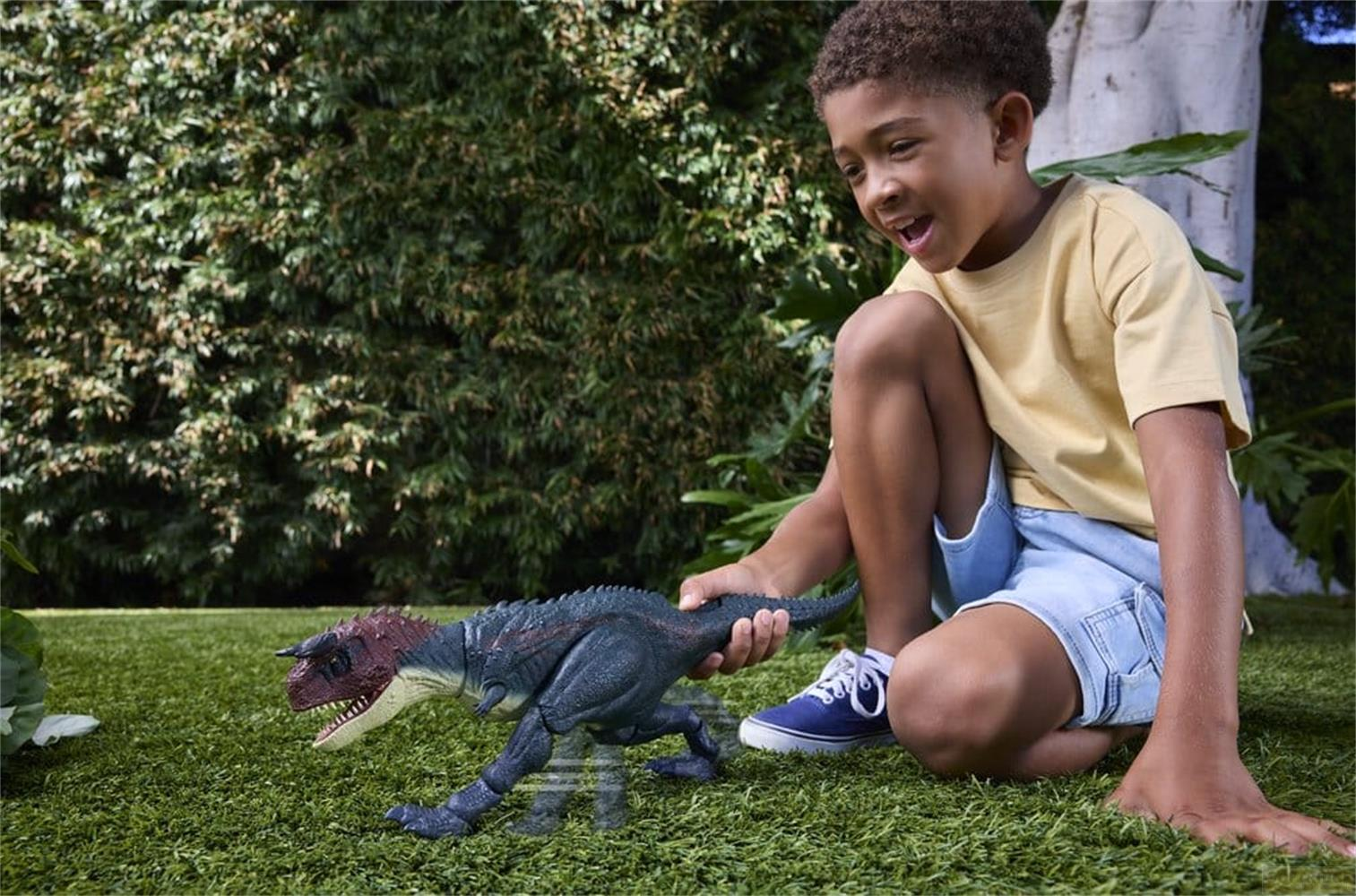 Un niño juega con un dinosaurio de juguete en el césped al aire libre.