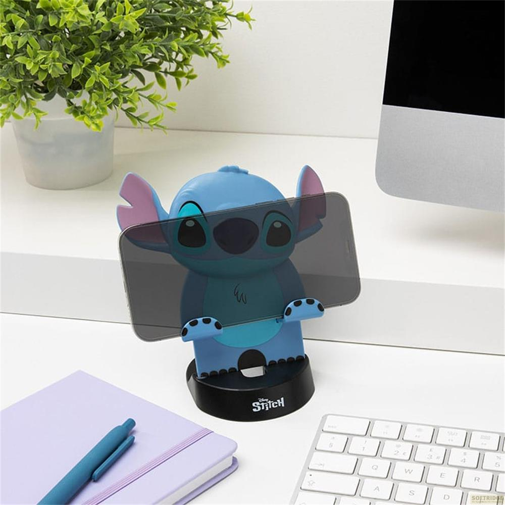 Uchwyt na telefon Stitch trzyma smartfon. Obok zeszyt i klawiatura.