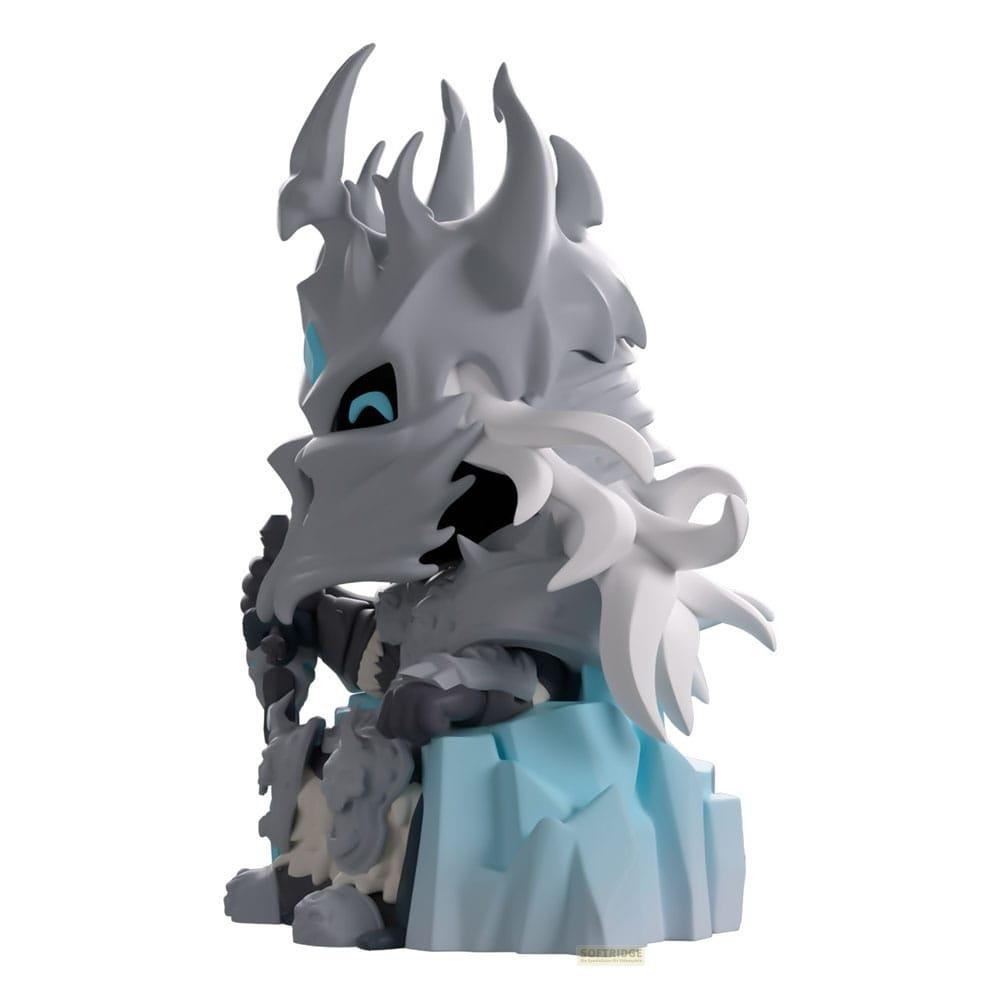 Eine weiße und graue Figur sitzt auf einem Eisblock, mit blauen Augen und scharfen Hörnern.