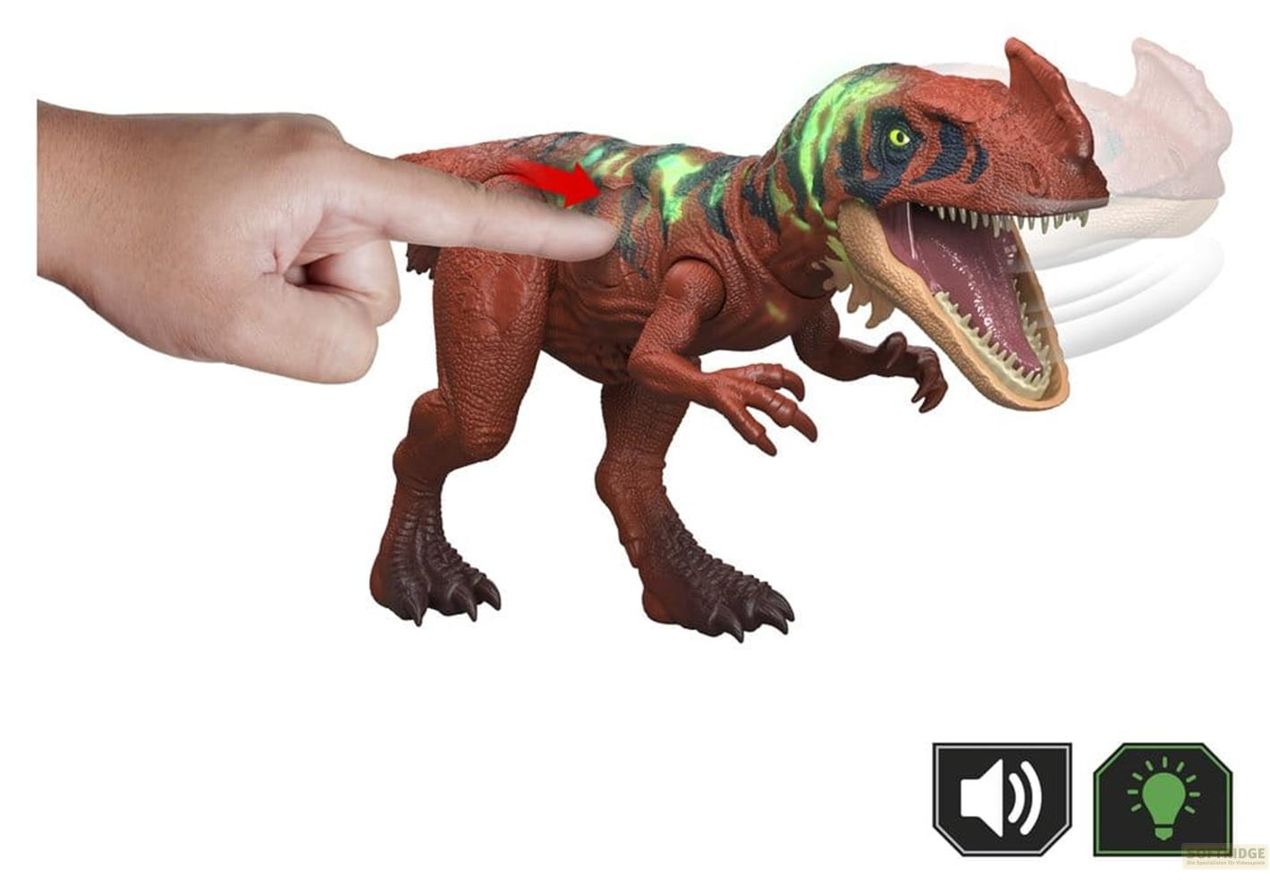 Un dedo presiona un dinosaurio marrón con rayas verdes, con la boca muy abierta.