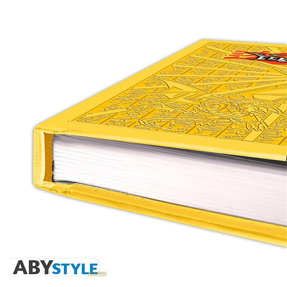 Un livre jaune avec un dragon en relief sur la couverture, pages blanches.